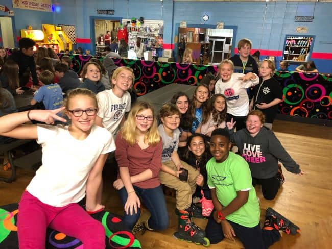 Group of young teens at a roller skating group event.